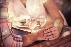 Couple holding hands at dinner at home in the dining room.jpeg