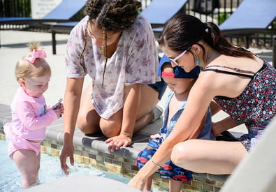 women with kids playing in pool