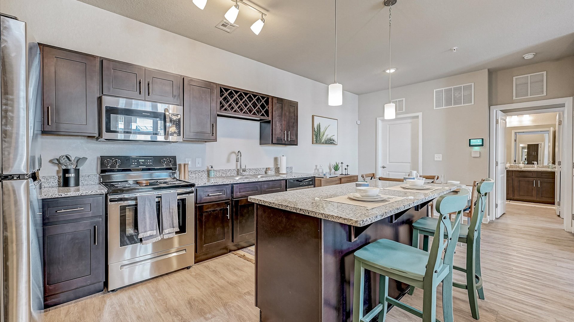 Open Concept Modern Kitchen with Island and Bathroom at Springs at Flagler Center Apartments in Jacksonville, FL