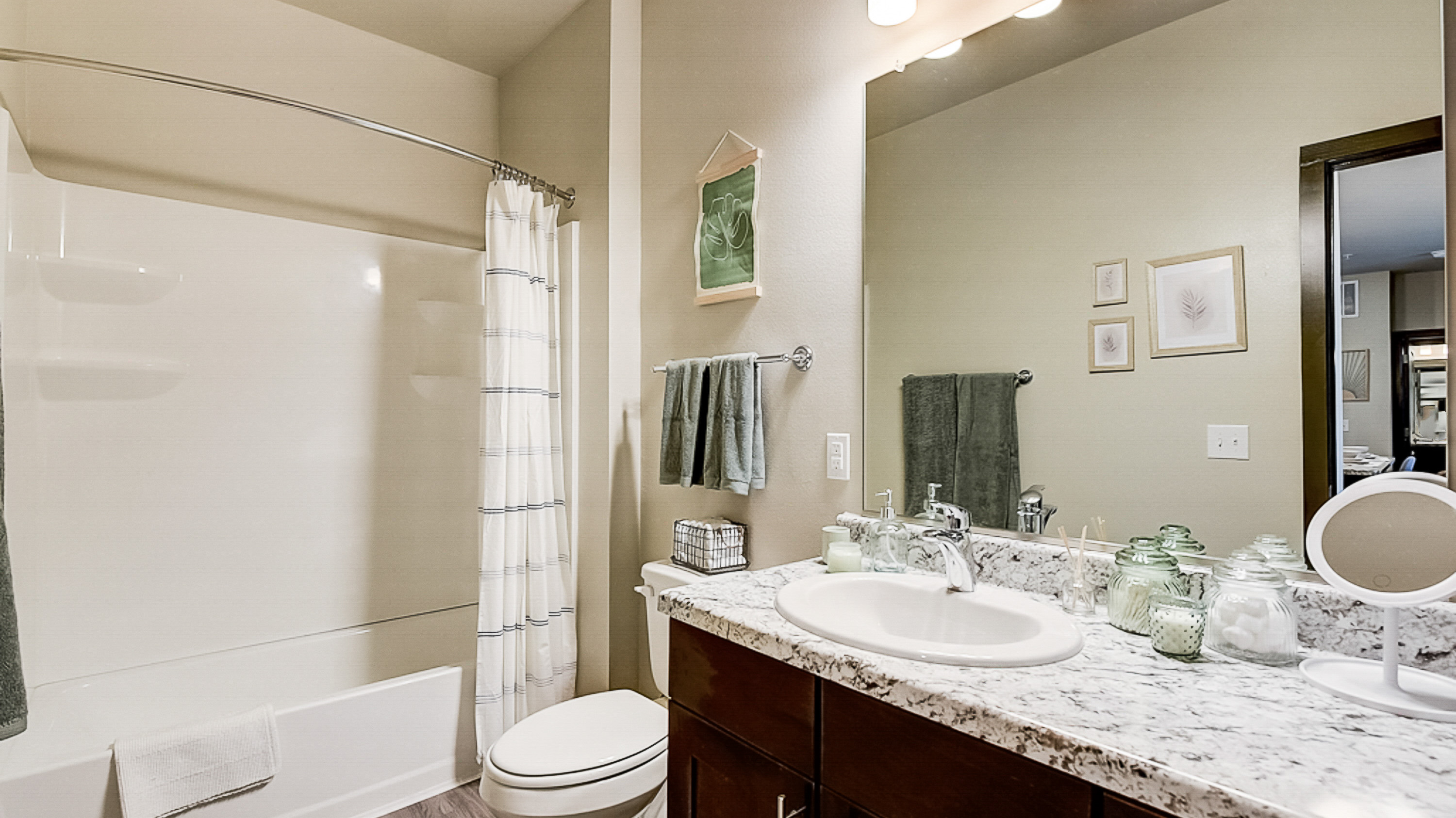 Large mirror, tub, and vanity int he bathroom at Springs at Grand Prairie apartments-46