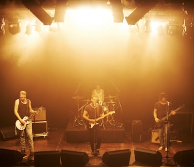 4 piece rock band playing on a stage