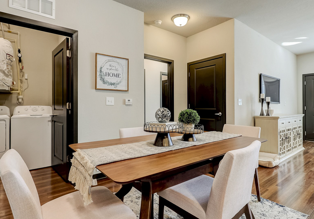 Open concept dining space in front of included washer and dryer room at Springs at Newnan Apartments in Georgia