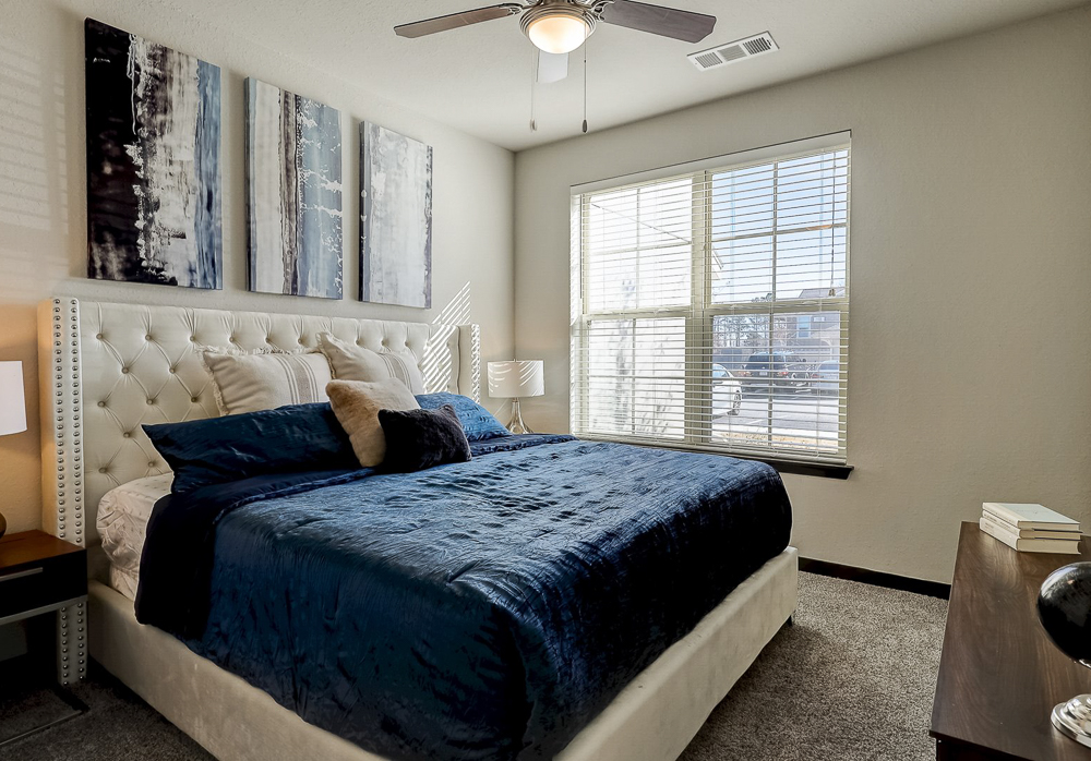 Master Bedroom with large windows and king bed at Springs at Newnan Apartments in Georgia-63