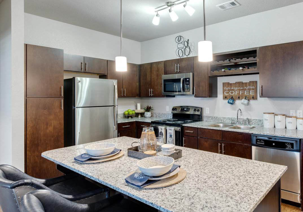 Luxury apartment kitchen with granite countertops and stainless steel appliances at Springs at Lakeline.